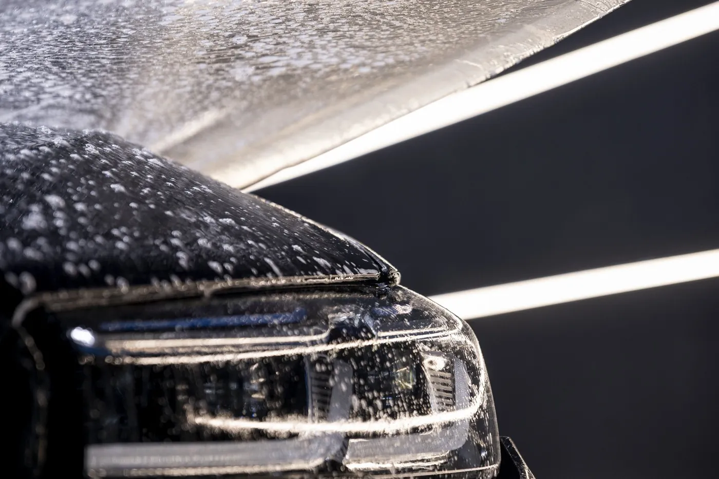 Car covered in snow foam during a hand wash